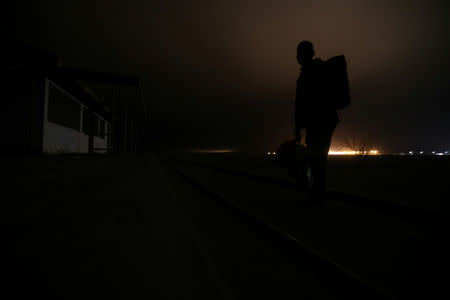 A Cuban migrant crosses the Chilean and Peruvian border following a train line to avoid frontier check points, at a mined area of desert in Arica, Chile, November 15, 2018. REUTERS/Ivan Alvarado