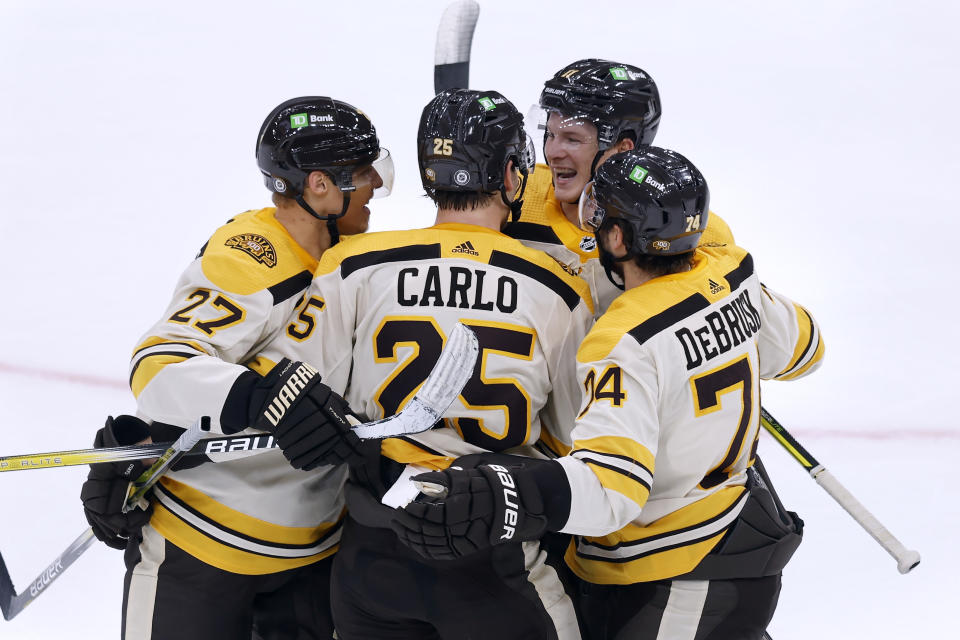 Boston Bruins' Trent Frederic (11) celebrates his goal against the Montreal Canadiens with Hampus Lindholm (27), Brandon Carlo (25) and Jake DeBrusk (74) during the first period of an NHL hockey game Saturday, Nov. 18, 2023, in Boston. (AP Photo/Michael Dwyer)