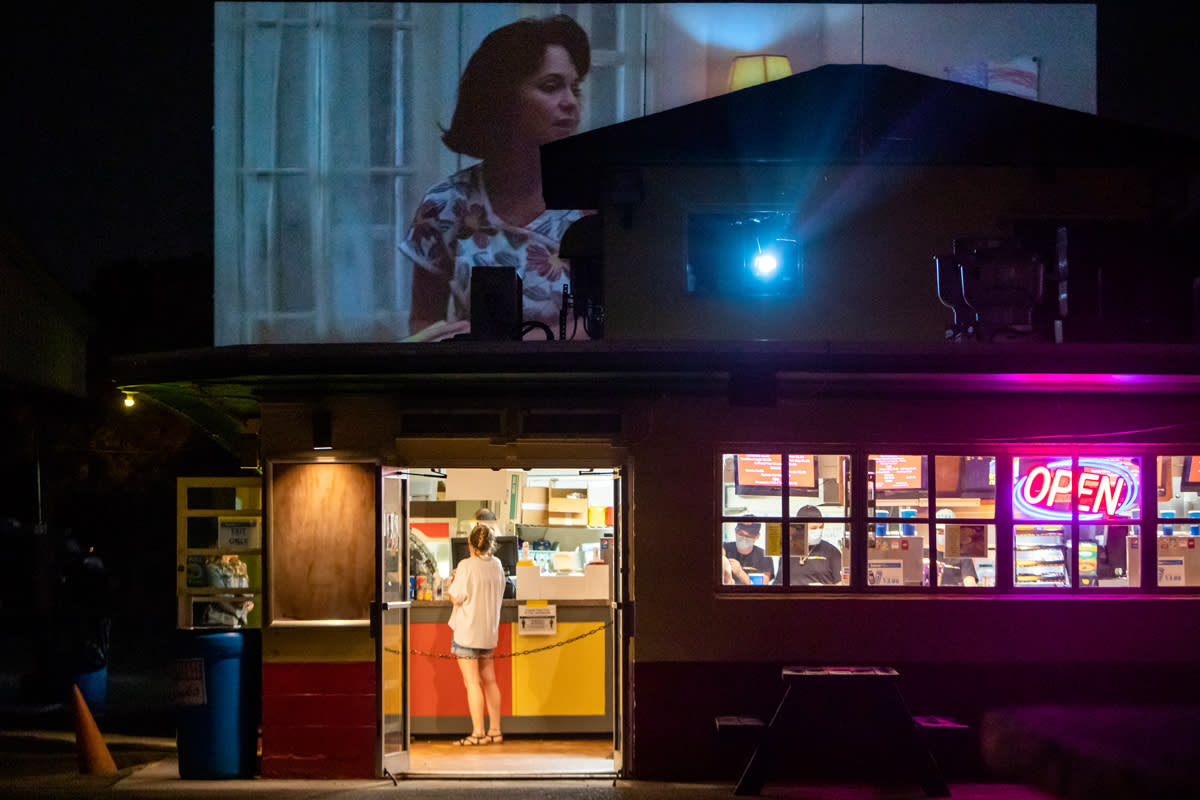 A woman buys food at the concession stand at a drive-in movie theater. 