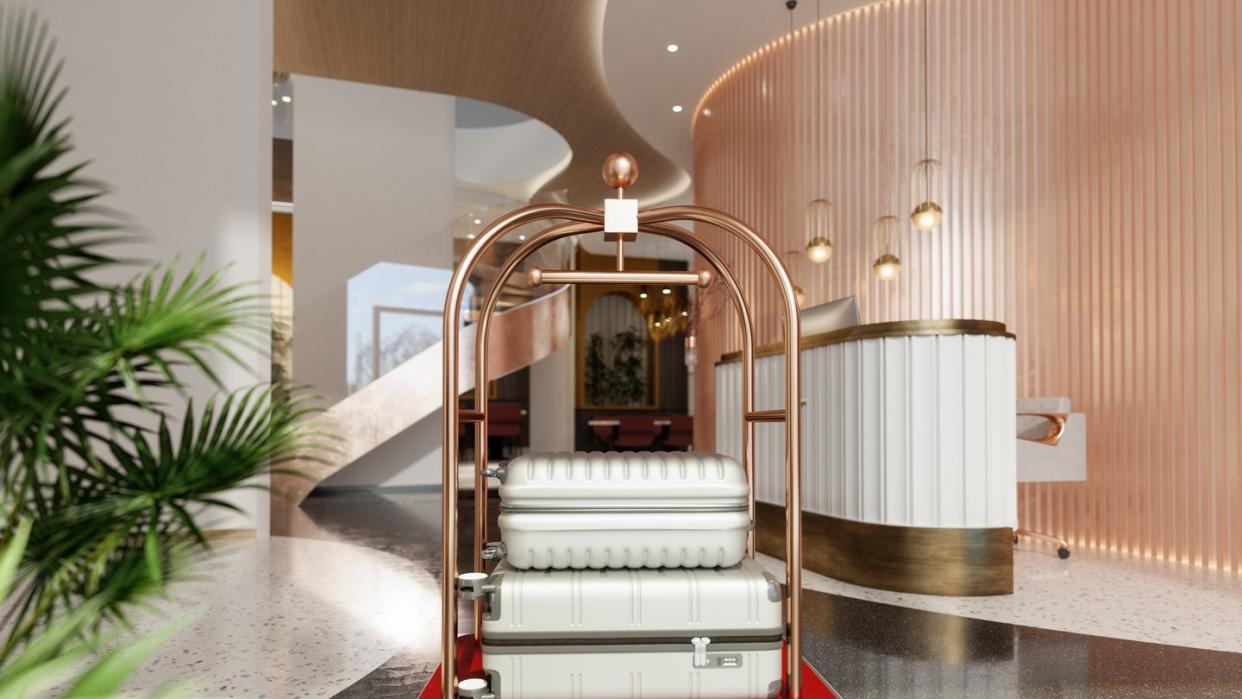 luxury hotel entrance with luggage cart, suitcases and side view of reception desk