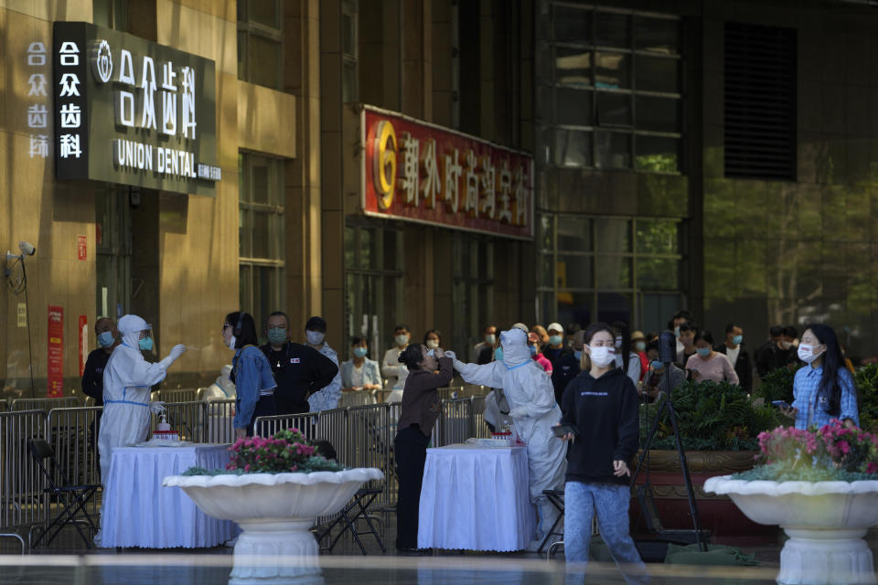 Residents line up for COVID mass testing set up at a shuttered commercial office complex on Sunday, May 15, 2022, in Beijing. (AP Photo/Andy Wong)