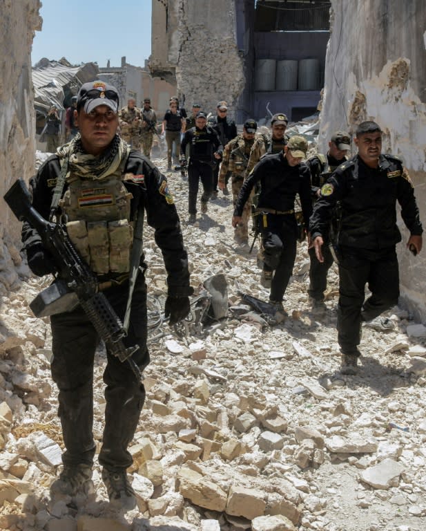 Iraqi forces trudge through the rubble of a building as they advance through the Old City of Mosul on June 25, 2017