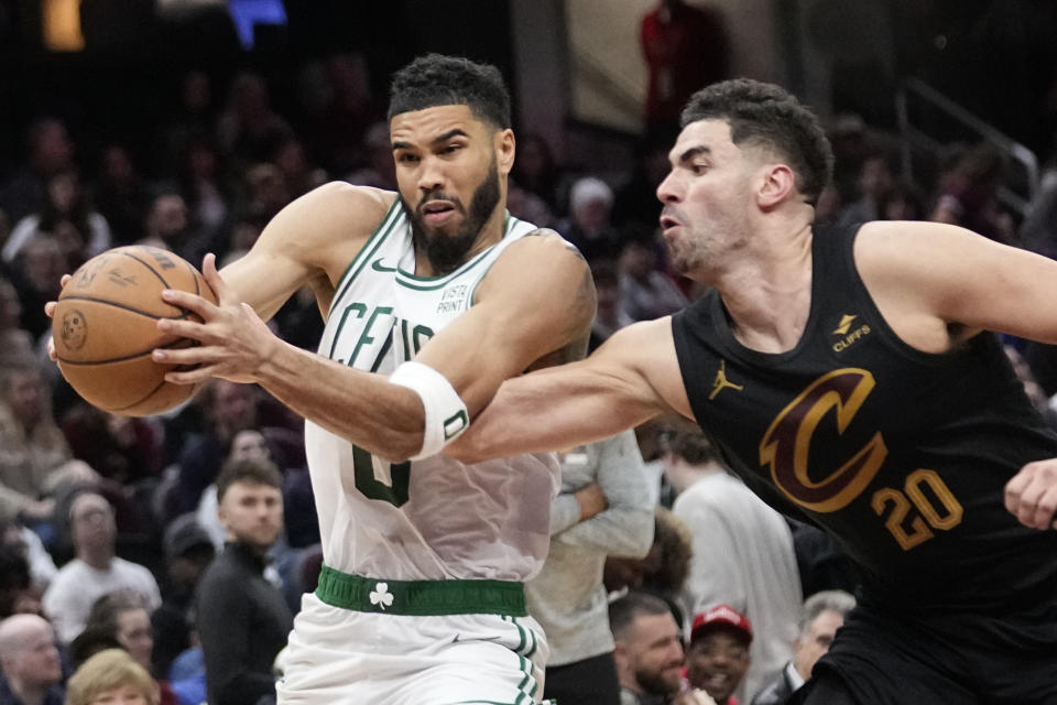 Boston Celtics forward Jayson Tatum, left, drives past Cleveland Cavaliers forward Georges Niang (20) in the second half of an NBA basketball game, Tuesday, March 5, 2024, in Cleveland. (AP Photo/Sue Ogrocki)