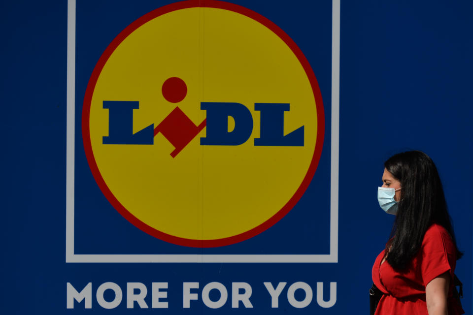 A woman wearing a face mask walks past a LIDL logo in Dublin city centre. 
On Thursday, 01 July 2021, in Dublin, Ireland. (Photo by Artur Widak/NurPhoto via Getty Images)