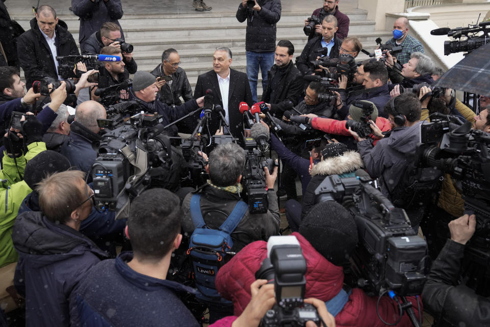 Hungary's nationalist prime minister Viktor Orban, center, talks to the media after casting his vote for general election in Budapest, Hungary, Sunday, April 3, 2022. Orban seeks a fourth straight term in office, a coalition of opposition parties are framing the election as a referendum on Hungary's future in the West. (AP Photo/Petr David Josek)