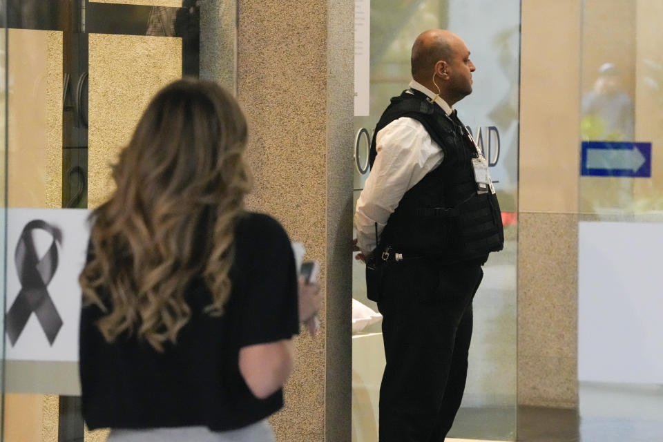 A security guard watches as shoppers return to the Westfield shopping mall at Bondi Junction in Sydney, Friday, April 19, 2024. The Sydney shopping mall reopened for business on Friday for the first time since it became the scene of a mass stabbing in which six people died on Saturday, April 13. (AP Photo/Mark Baker)