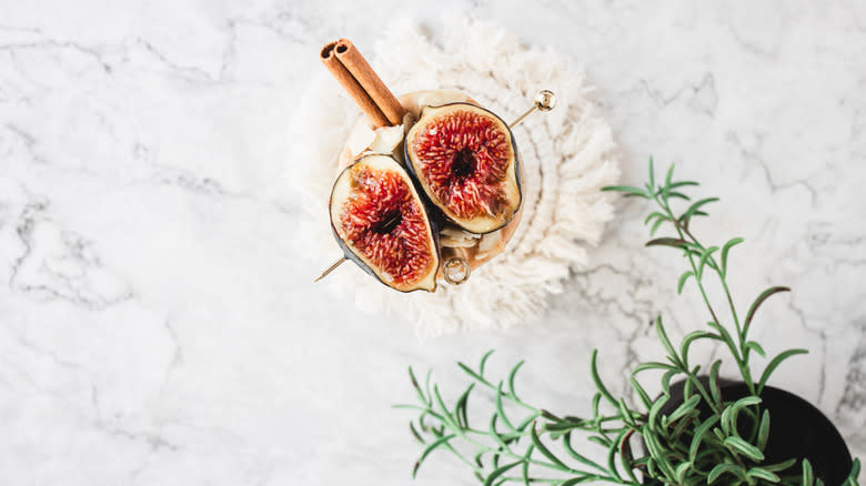 smoothie garnished with figs on skewer, almonds and cinnamon