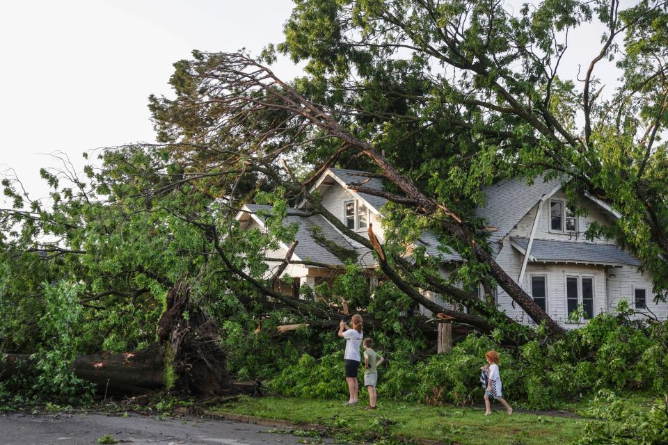 A home in Claremore, Oklahoma buried under fallen trees after a tornado on Sunday. At least 21 people were killed by severe weather in the central US this weekend (AP)