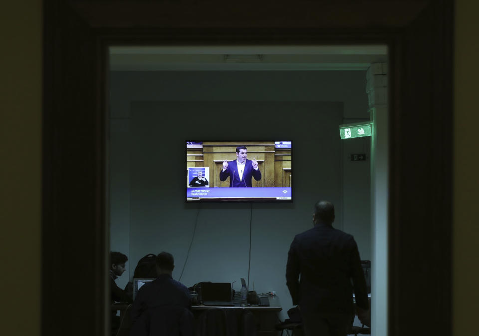 A TV monitor inside the Greek paliament shows the speech of Greece's Prime Minister Alexis Tsipras during a parliament session in Athens on Tuesday, Dec. 18, 2018. Greek lawmakers are debating the heavily-indebted country's draft budget for 2019, the first since Greece exited an eight-year bailout program. (AP Photo/Petros Giannakouris)