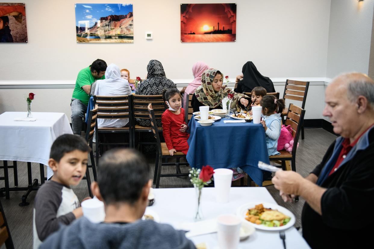 The women of the Siddiqi family sit together in the back during a meet up of recent Afghan refugees, veterans and others at Afghan Kabob on Sunday, Nov. 14, 2021.