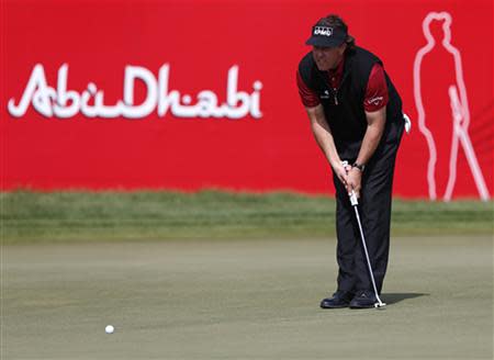 Phil Mickelson of the U.S. lines the ball on the 18th green during the Abu Dhabi Golf championship January 18,2014. REUTERS/Ahmed Jadallah