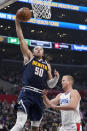 Denver Nuggets forward Aaron Gordon, left, shoots as Los Angeles Clippers center Mason Plumlee defends during the first half of an NBA basketball game Thursday, April 4, 2024, in Los Angeles. (AP Photo/Mark J. Terrill)