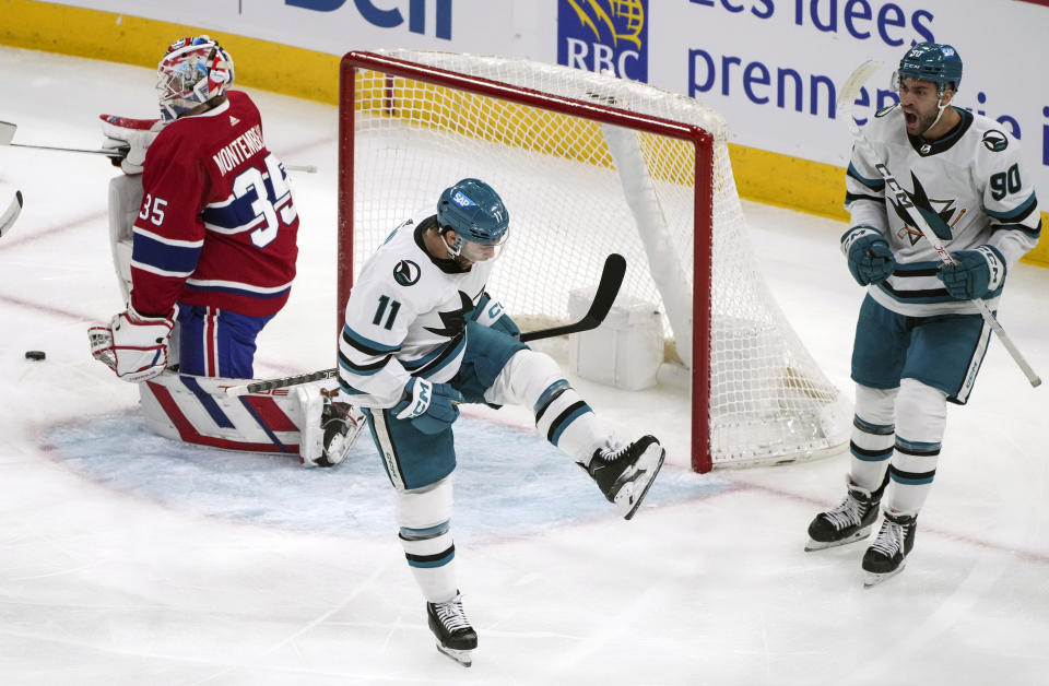 San Jose Sharks' Luke Kunin (11) celebrates with teammate Justin Bailey (90) after scoring against Montreal Canadiens goaltender Sam Montembeault (35) during first-period NHL hockey game action in Montreal, Thursday, Jan. 11, 2024. (Christinne Muschi/The Canadian Press via AP)