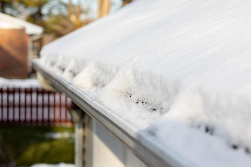 Snow and ice in gutters and on the roof during winter