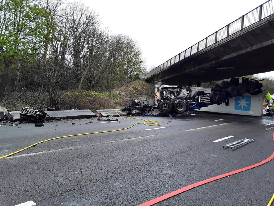 Dramatic photographs show the aftermath of a horror motorway crash which has left a lorry split in half. See SWNS story SWLNcrash; Emergency services were called to the M6 in Staffordshire following the smash involving a lorry which overturned and caught fire earlier today (Sun).  Traffic was stopped in both directions between Junction 12 for Cannock and Junction 13 for Stafford as police and ambulance crews rushed to the scene. Shocking images show how the HGV was completely split in two by the impact of the collision which also left its engine strewn across the carriageway. 