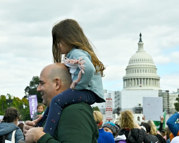 A young girl surveys the crowd from up high in Washington, D.C. (Photo: Shannon Finney via Getty Images)