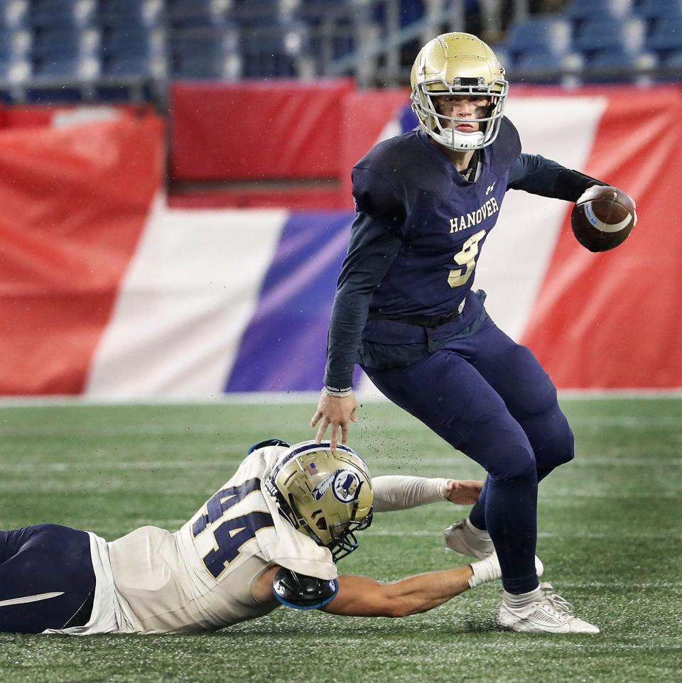 Hanover QB Ben Scalzi eludes a sack attempt by Foxboro's Brandon Mazenkas-O'Grady during the MIAA Division 5 state championship game at Gillette Stadium on Friday, Dec. 1, 2023.