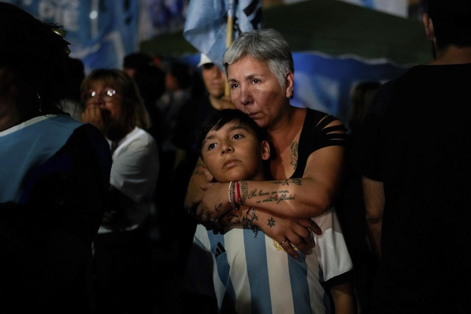 Supporters of Argentina's Economy Minister Sergio Massa, presidential candidate of the Peronist party, embrace outside his campaign headquarter after he conceded defeat to opposition candidate Javier Milei in the presidential runoff election in Buenos Aires, Argentina, Sunday, Nov. 19, 2023. (AP Photo/Matias Delacroix)