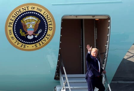 U.S. President Donald Trump waves as he disembarks Air Force One during a refueling stop at Joint Base Elmendorf, Alaska, U.S. on his way to the G-20 Summit in Osaka