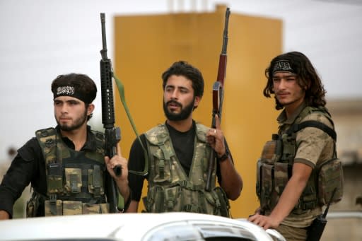 Turkey-backed Syrian fighters gather on the road between the Syrian towns of Tal Abyad and Kobane on the Turkish border