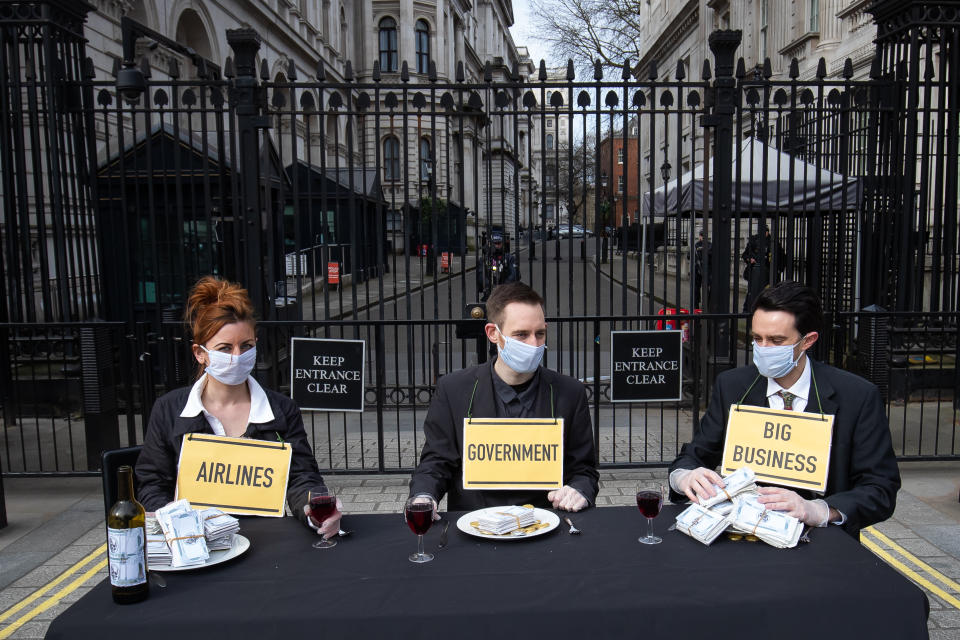 Protesters from a group called 'Pause the System' wear face masks as they demonstrate outside Downing Street in London. The group are calling for greater action from the government as the UK's coronavirus death toll reached 144 as of 1pm on Thursday, with around four in 10 of all deaths so far in London.