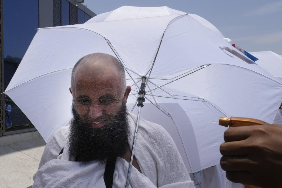 A Muslim pilgrim is sprayed with refreshing water at the Mina tent camp in Mecca, Saudi Arabia, during the annual Hajj pilgrimage, Monday, June 26, 2023. Muslim pilgrims are converging on Saudi Arabia's holy city of Mecca for the largest Hajj since the coronavirus pandemic severely curtailed access to one of Islam's five pillars. (AP Photo/Amr Nabil)