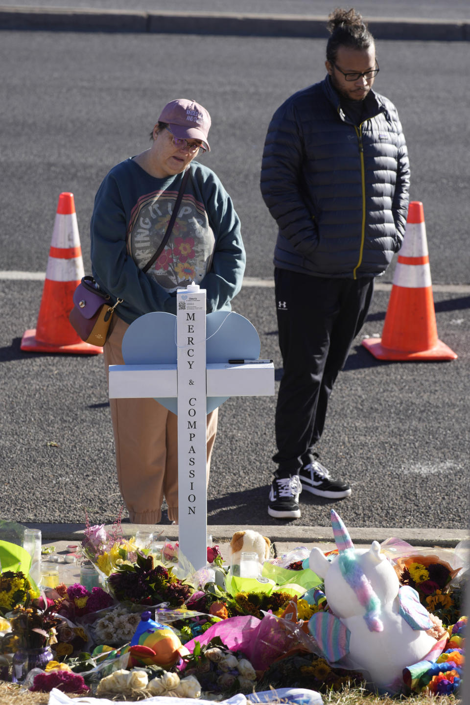 Mourners pause at a cross for one of victims of a weekend mass shooting at a nearby gay nightclub on Tuesday, Nov. 22, 2022, in Colorado Springs, Colo. Anderson Lee Aldrich opened fire at Club Q, in which five people were killed and others suffered gunshot wounds before patrons tackled and beat the suspect into submission. (AP Photo/David Zalubowski)