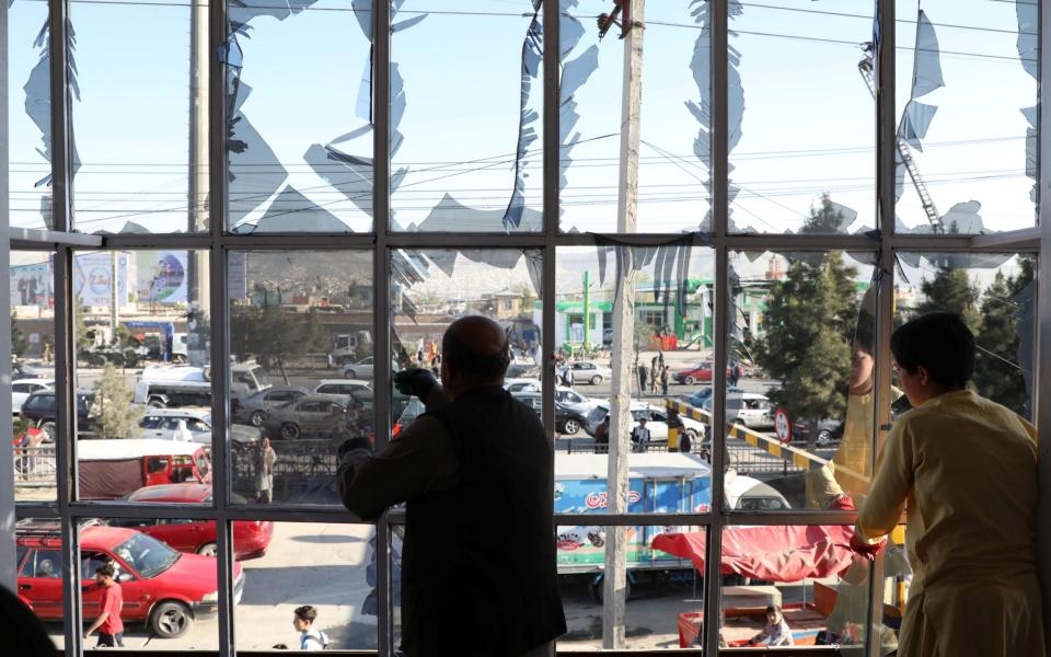 Afghans remove broken glass from a window of their house near the site of a suicide bomb blast in Kabul, Afghanistan - Omar Sobhani/Reuters