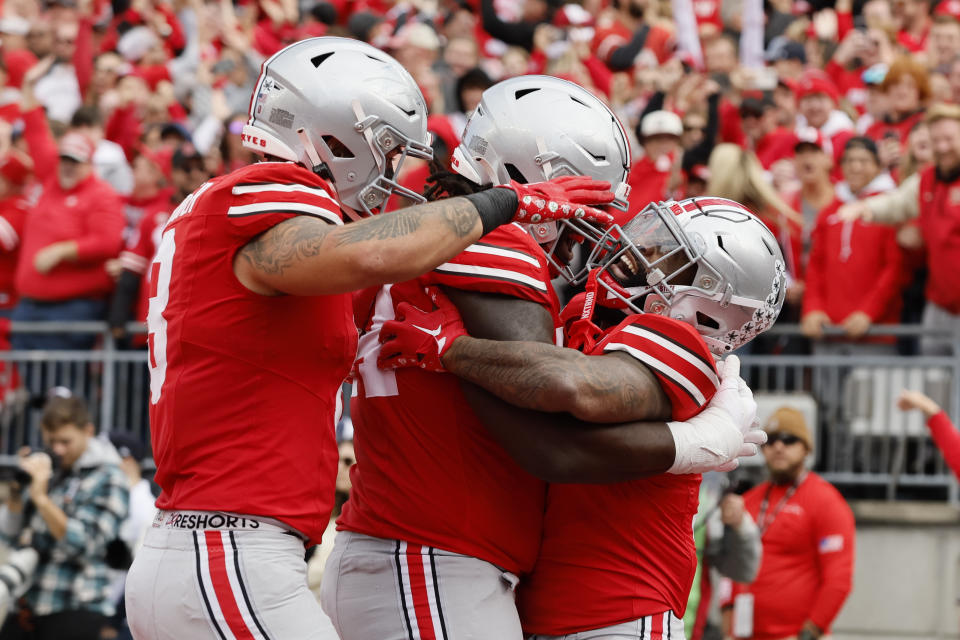 Ohio State running back Miyan Williams, right, celebrates his touchdown with teammates Cade Stover, left, and Donovan Jackson during the first half of an NCAA college football game against Penn State, Saturday, Oct. 21, 2023, in Columbus, Ohio. (AP Photo/Jay LaPrete)