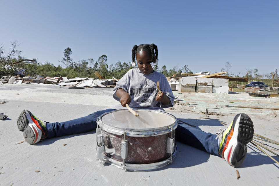 Ca'Loni Booth, 6, bangs away at what remains of the drum set in the slab that was James Hill Church in Prentiss, Miss., Tuesday, April 14, 2020. The church and much of its south Prentiss neighborhood was heavily damaged by a tornado Sunday, one of several that swept the state, causing a number of deaths. (AP Photo/Rogelio V. Solis)