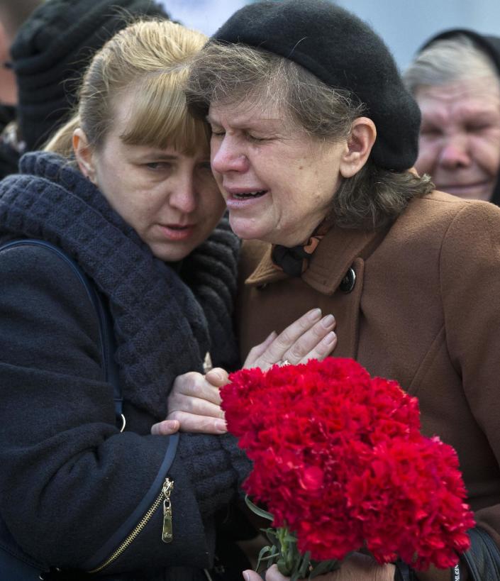 Relatives of Ukrainian soldier Sergey Kokurin, 35, during his funeral in Simferopol, Crimea, Saturday, March 22, 2014. A few hundred mourners gathered to pay their last respects to two men who were shot dead earlier in the week. Ukrainian soldier Sergey Kokurin, 35 and Russian Cossack militiaman Ruslan Kazakov, 34, are the only known victims of what has otherwise been a bloodless takeover of Crimea by Russia.(AP Photo/Vadim Ghirda)