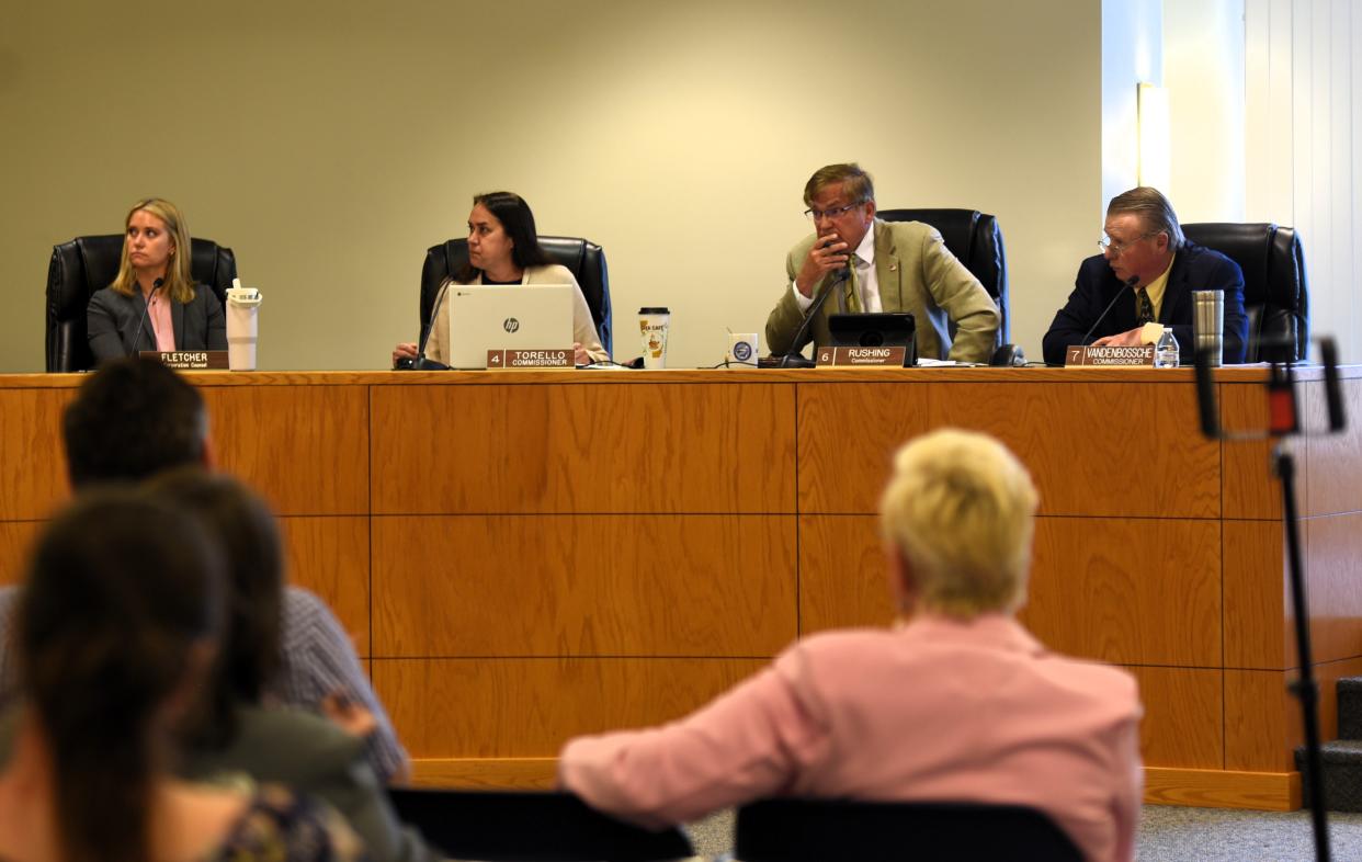 St. Clair County Commissioners Dave Vandenbossche, from right, Dave Rushing, and Joi Torello listen across the dais to other board members' remarks on Thursday, May 2, 2024.