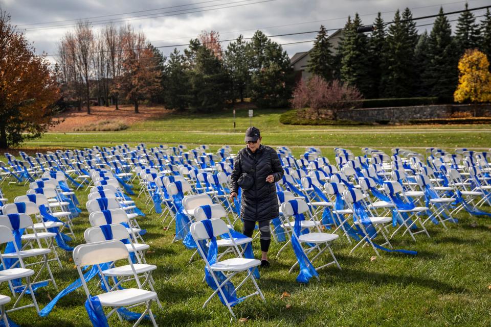 Itzi Saar, of West Bloomfield, walks among the memorial for the Israeli hostages being held by Hamas erected near the Temple Shir Shalom in West Bloomfield on Oct. 31, 2023. Saar, who says she is originally from Israel, is more frightened here with the growing antisemitism, but it makes her feel better knowing her husband is volunteering at the Sheba hospital in Tel Aviv as rehab specialist.