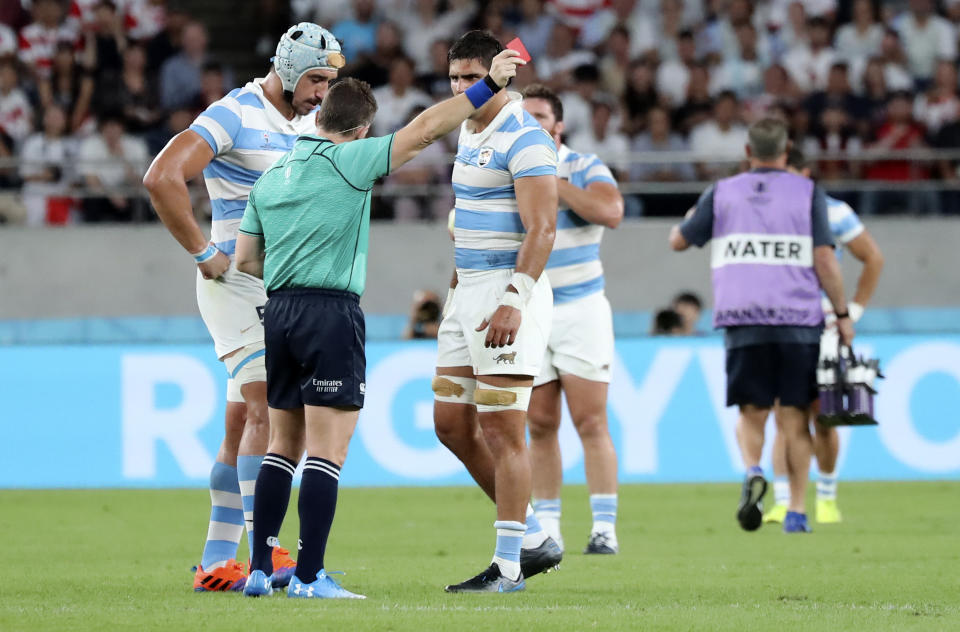 Referee Nigel Owens shows Argentina's Tomas Lavanini, left, a red card after a dangerous tackle during the Rugby World Cup Pool C game at Tokyo Stadium between England and Argentina in Tokyo, Japan, Saturday, Oct. 5, 2019. (AP Photo/Eugene Hoshiko)