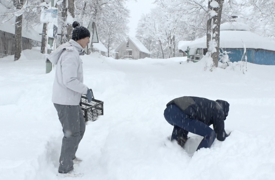 ▲小禎、胡釋安以狗爬式在雪地裡挖找蘋果。