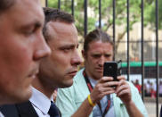 Oscar Pistorius, second left, leaves the high court after the fourth day of his trial in Pretoria, South Africa, Thursday, March 6, 2014. Pistorius is charged with murder in the shooting death of girlfriend Reeva Steenkamp in the pre-dawn hours of Valentine's Day 2013. (AP Photo/Schalk van Zuydam)