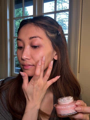 <p>Clarins USA</p> Brenda Song applies Clarins' Multi-Active cream