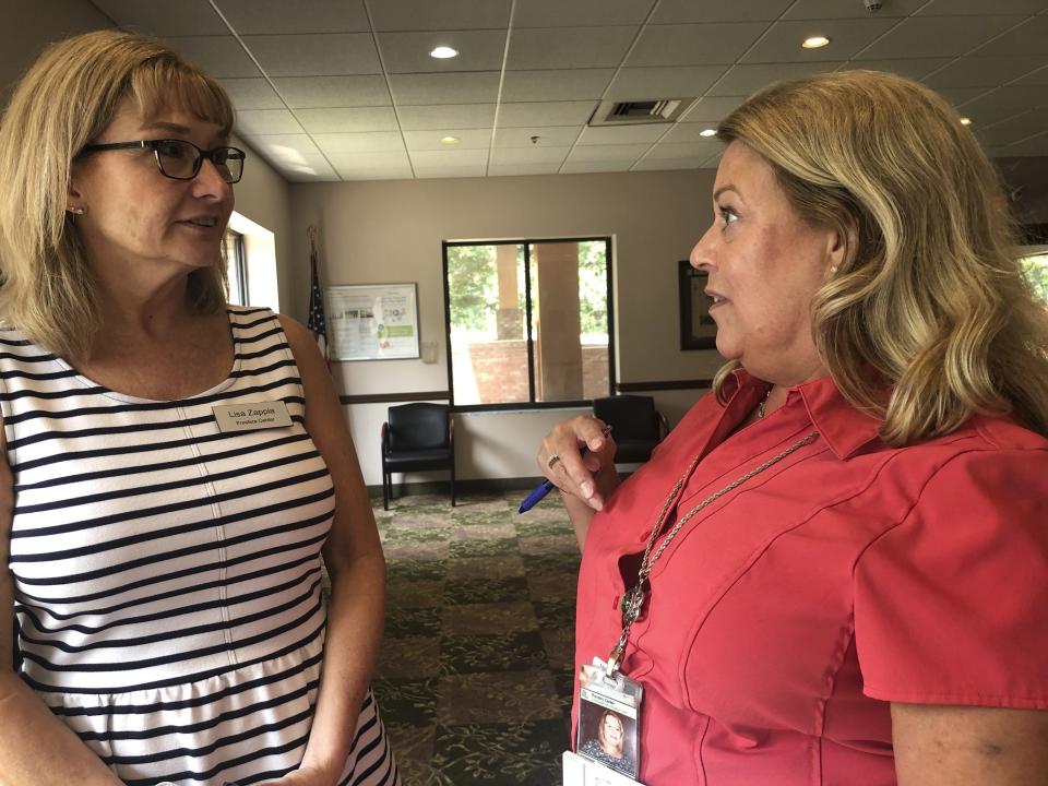 Lisa Zappia, left,chief executive officer of mental health and addiction treatment services provider Prestera Center, speaks with Prestera addictions counselor Kim Miller Wednesday, July 21, 2021, at the nonprofit group's headquarters in Huntington, W.Va. In one of the epicenters of the U.S. opioid explosion, the nonprofit group really could use some money. Whether from a potential national settlement deal with big U.S. drug distribution companies or from some other source, an infusion of cash would help stem the tide of losses in staffing and other areas in recent years, along with the strain caused by the coronavirus pandemic. (AP Photo/John Raby)