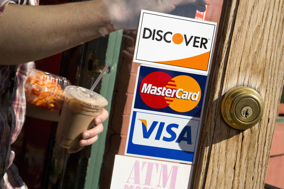 A coffee shop displays signs for Visa, MasterCard and Discover, in Washington, May 1, 2013. This logo has been updated and is no longer in use.  REUTERS/Jonathan Ernst    (UNITED STATES - Tags: BUSINESS)