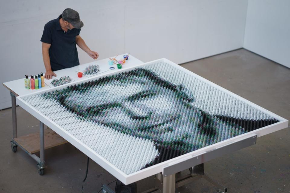 Joe Black adds the finishing touches to a portrait of David Bowie made from over 8600 guitar plectrums (Scott Garfitt/PinPep)
