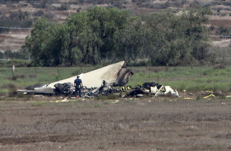Authorities investigate the crash site where a twin-engine Sabreliner collided with a single-engine Cessna 172 as both were on approach to land at Brown Field, in Otay Mesa, California August 17, 2015. REUTERS/Mike Blake