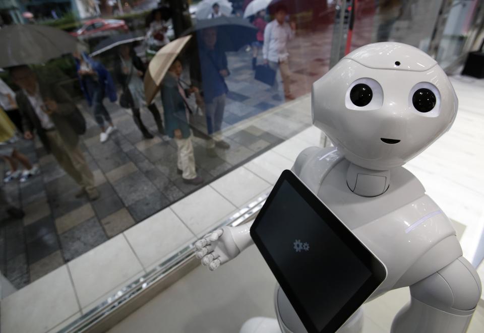 SoftBank Corp's human-like robot named 'pepper' is displayed at its branch as pedestrians look at in Tokyo