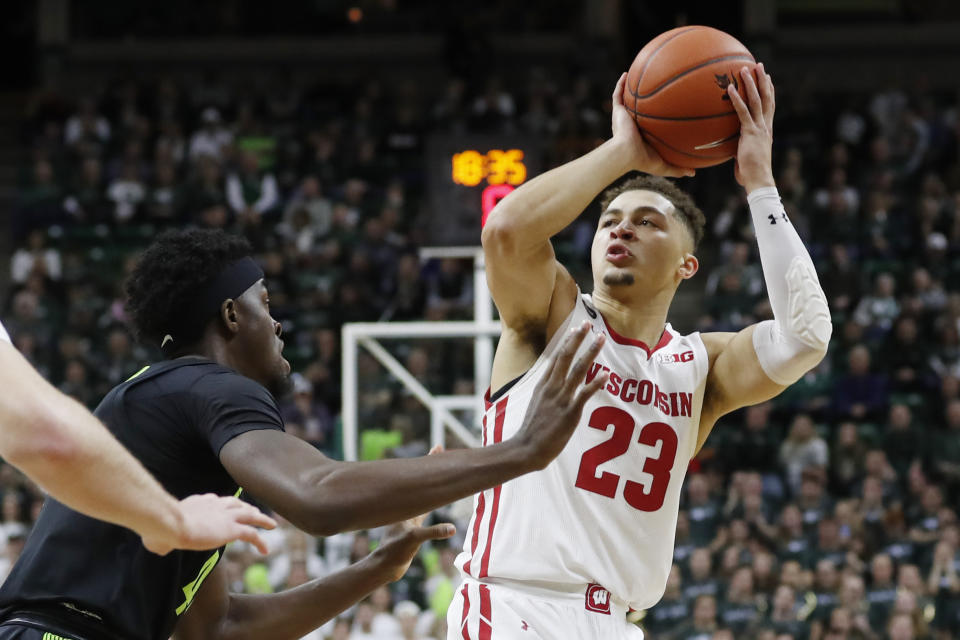 Wisconsin guard Kobe King (23) shoots over the defense of Michigan State forward Gabe Brown during the first half of an NCAA college basketball game, Friday, Jan. 17, 2020, in East Lansing, Mich. (AP Photo/Carlos Osorio)