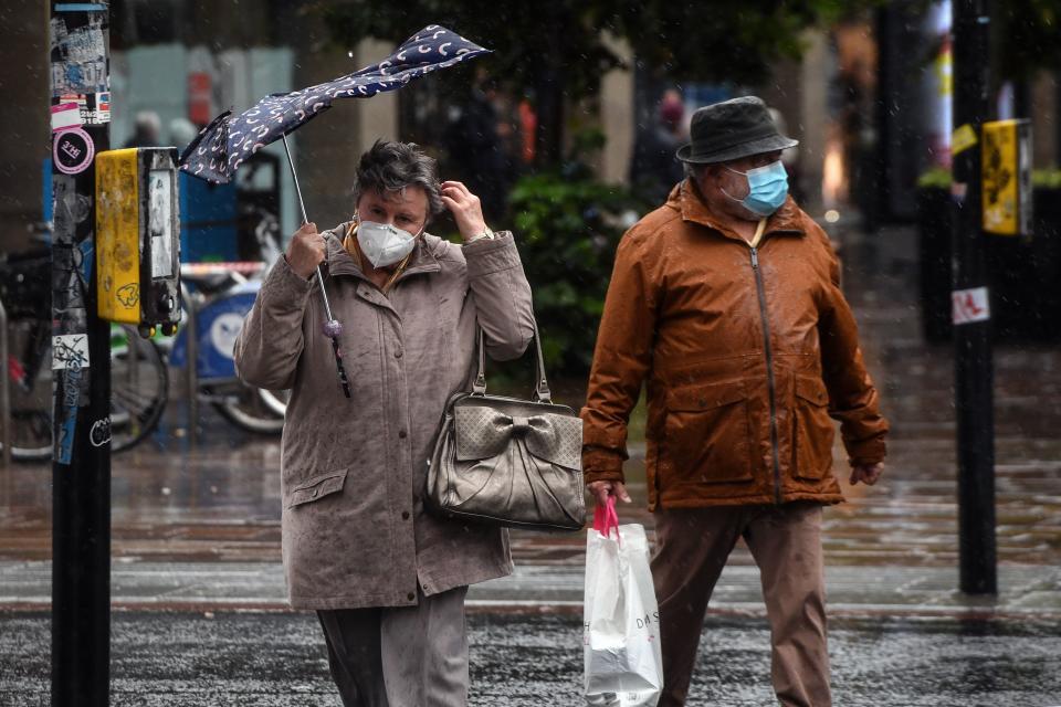 Pedestrians wearing protective face masks struggle against the wind in Glasgow city centre on August 25, 2020, as Storm Francis brings rain and high winds to the UK. (Photo by Andy Buchanan / AFP) (Photo by ANDY BUCHANAN/AFP via Getty Images)