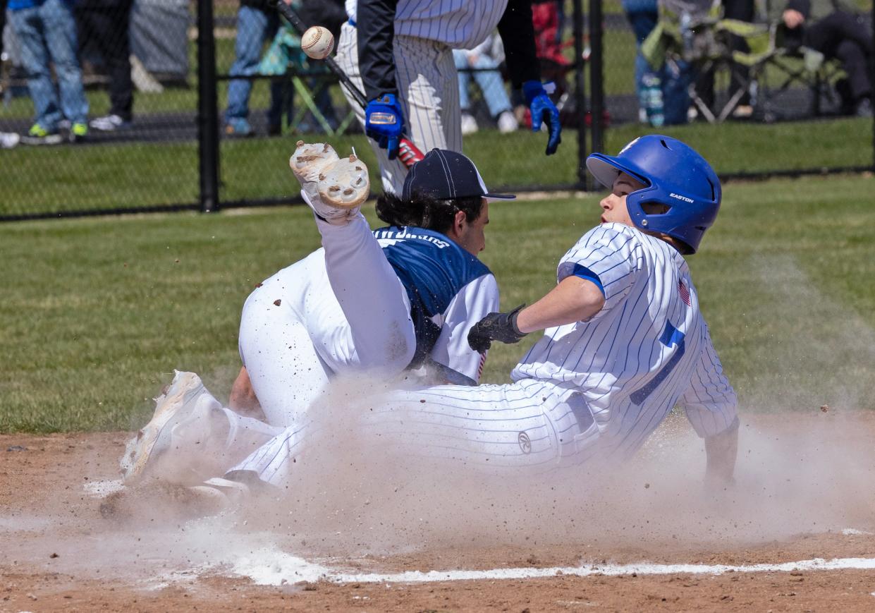 Adrian's Adam Parker slides safely into home during Saturday's doubleheader against Gaylord St. Mary's.