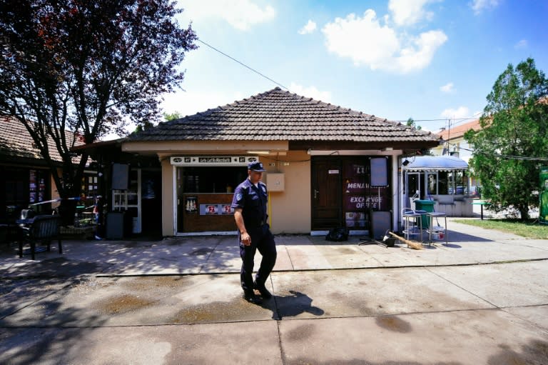 A Serbian policeman stands guards outside a cafe where a gunman killed five people in the northern village of Zitiste, on July 2, 2016
