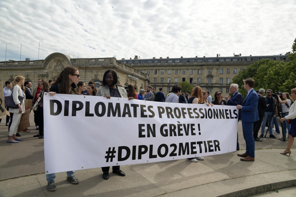 Diplomats hold a banner reading "Professional diplomats on strike" during a protest near the French Foreign Ministry Thursday, June 2, 2022 in Paris. Members of the French diplomatic corps are dropping their traditional reserve to go on a rare strike, angered by a planned reform they worry will hurt their careers and France's standing in the world. (AP Photo/Nicolas Garriga)