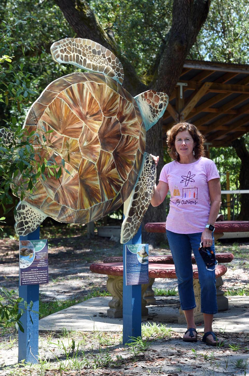 Emerald Coast Science Center Director Diane Fraser stands next to a turtle sculpture, one of many new outdoor exhibits the center has add recently.