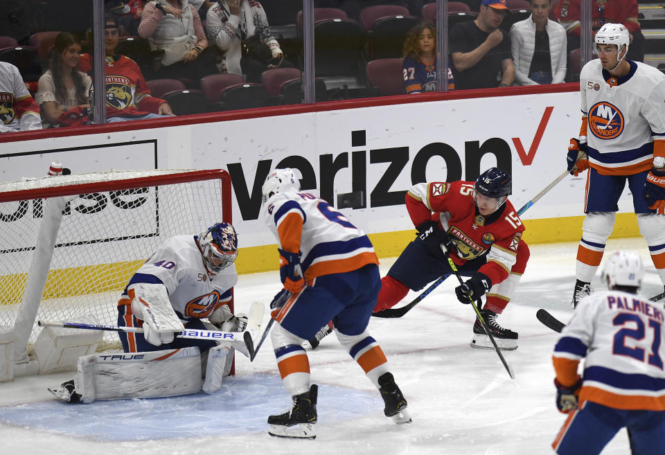 Florida Panthers' Anton Lundell (15) watches the puck slip past New York Islanders goalie Semyon Varlamov, left, during the first period of an NHL hockey game, Sunday, Oct. 23, 2022, in Sunrise, Fla. (AP Photo/Michael Laughlin)