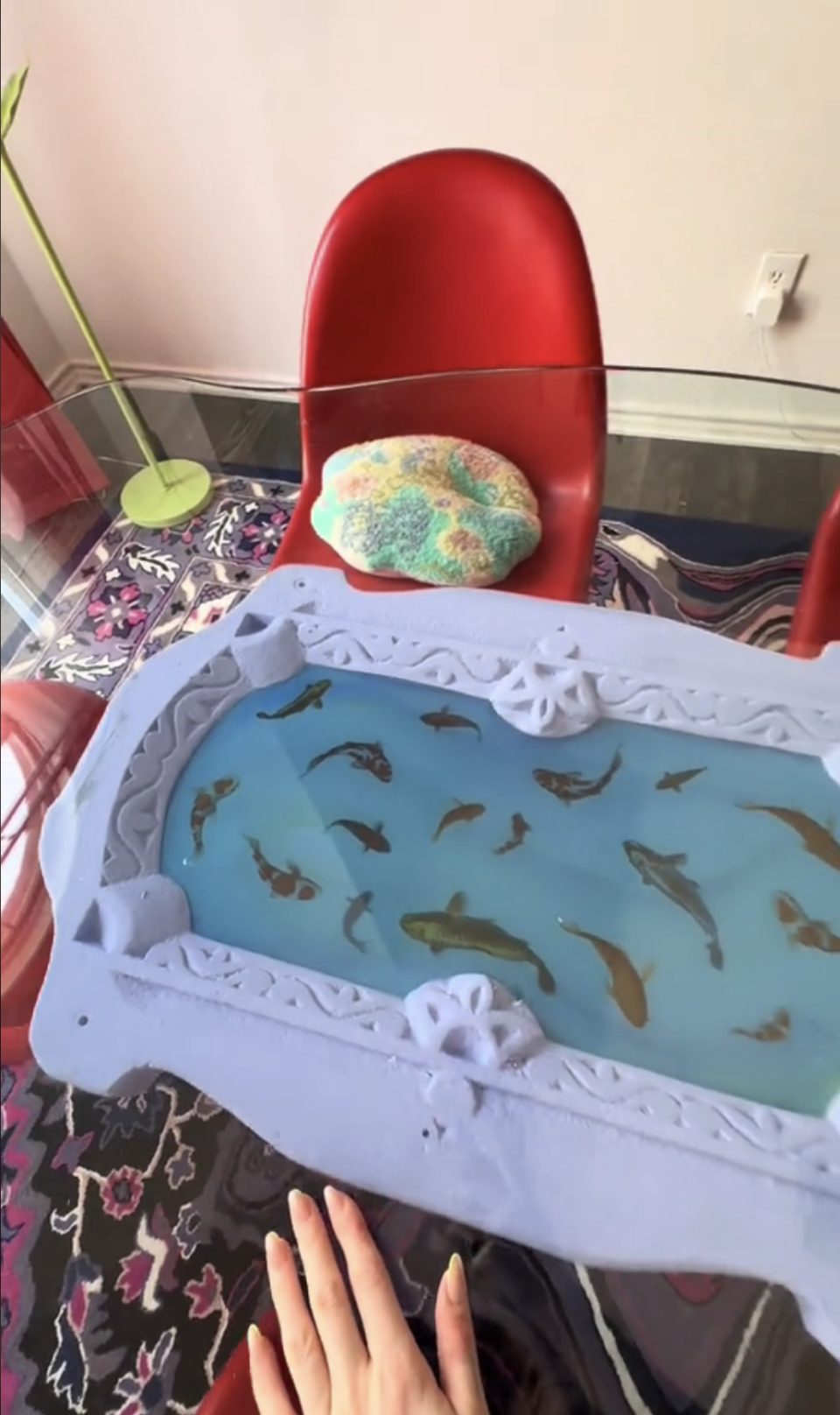 A unique aquarium coffee table with various fish, surrounded by home furnishings